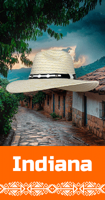 Banner promocional que muestra un sombrero Aguadeño colombiano de ala ancha, sobre una calle empedrada de un pintoresco pueblo en Colombia, resaltando la artesanía local.